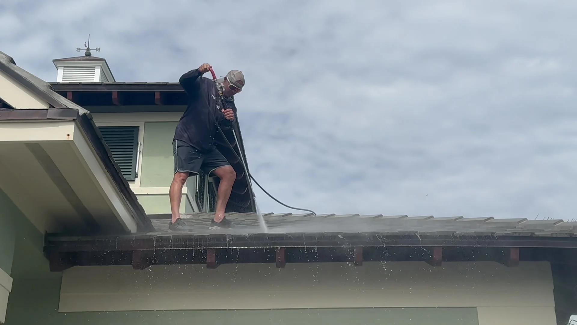 Surface Pros technician pressure-washing a barrel tile roof