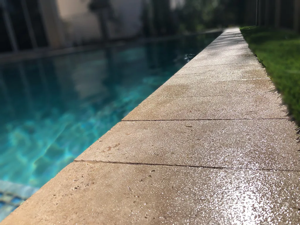 Close-up of SignaTrac's engineered grip texture on travertine coping